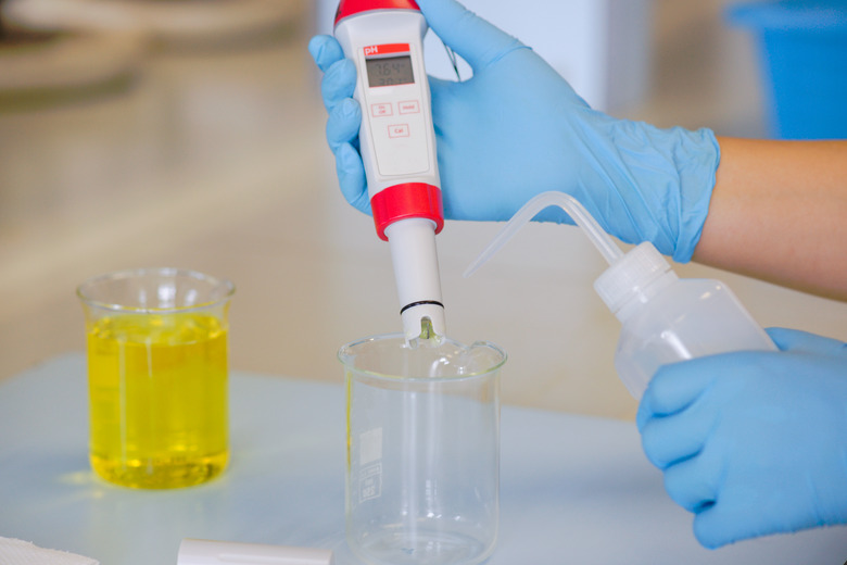 The scientist work at the chemical solution with handle pH meter