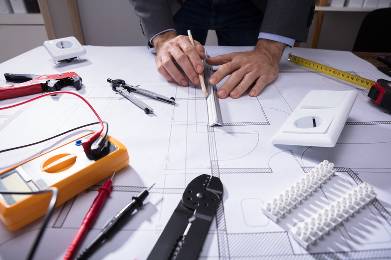 Architect Using Pencil To Draw Blueprint