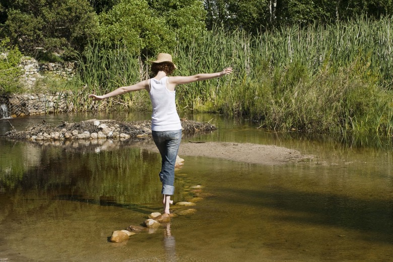 Woman crossing rocky stream