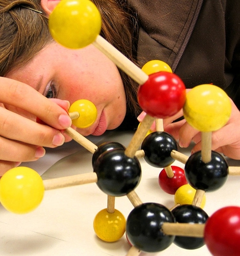 Female student putting together a large 3D molecular model