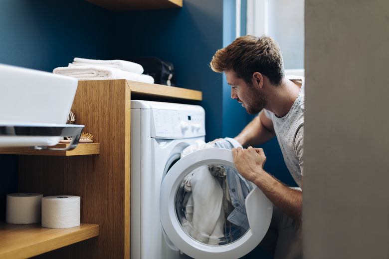 Young man doing the laundry at home