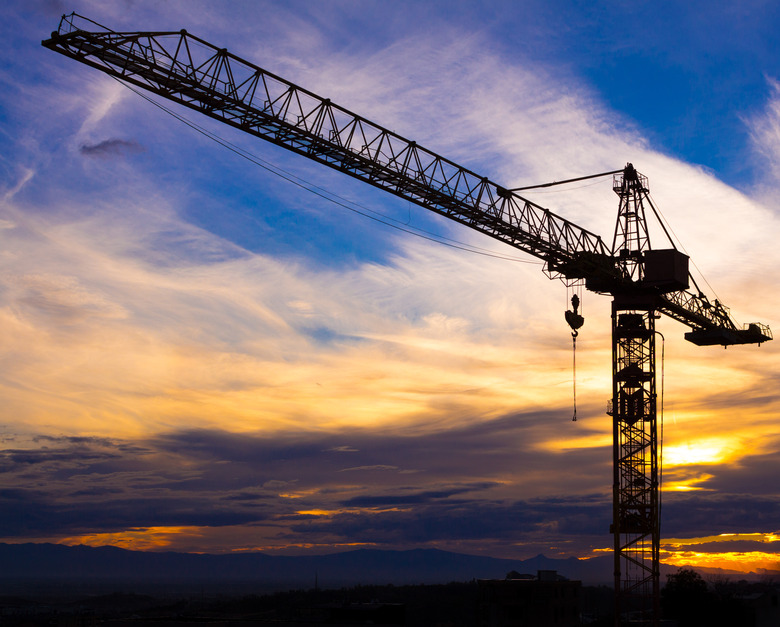 Crane silhouetted against the sunset with orange clouds