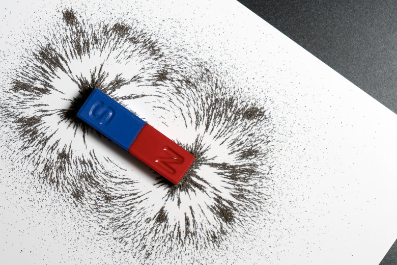 Red and blue bar magnet or physics magnetic with iron powder magnetic field on white background.