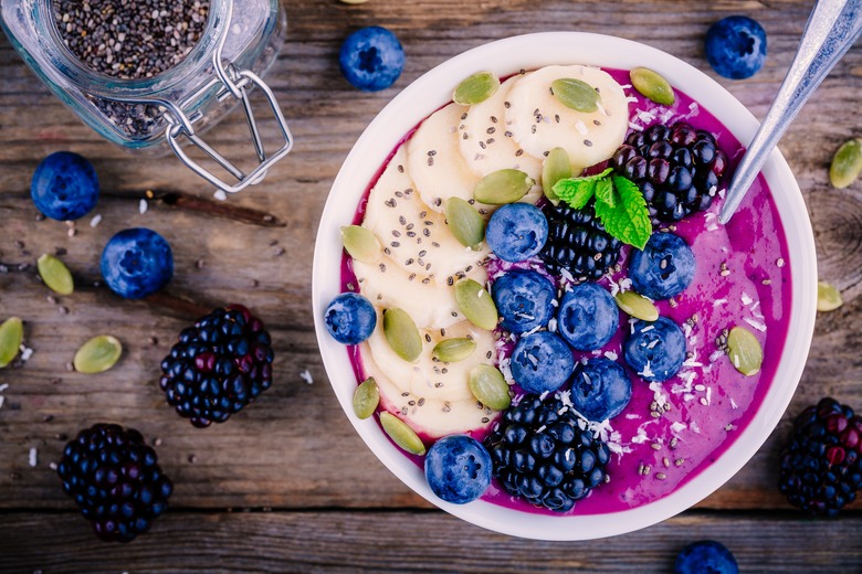 Smoothie bowl with fresh blackberries, blueberries, banana, sunflower seeds, pumpkin seeds, chia  seeds and coconut