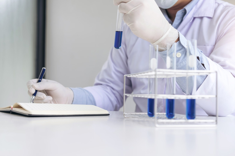 Scientist or medical in lab coat holding test tube with reagent, Laboratory glassware containing chemical liquid, Biochemistry laboratory research