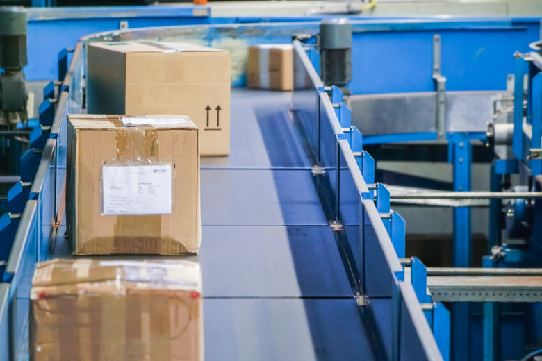 Parcels on conveyors with blurred industrial background