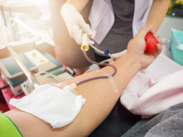 Nurse receiving blood from blood donor in hospital.