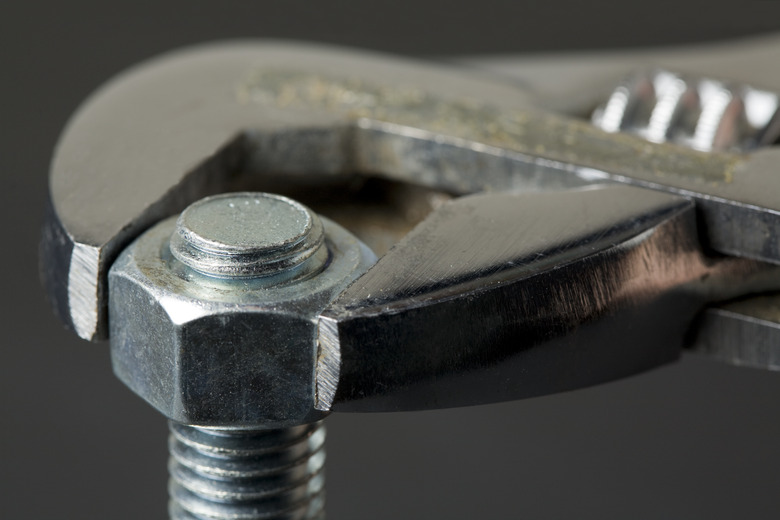 Close-up of a wrench attached to a bolt and screw