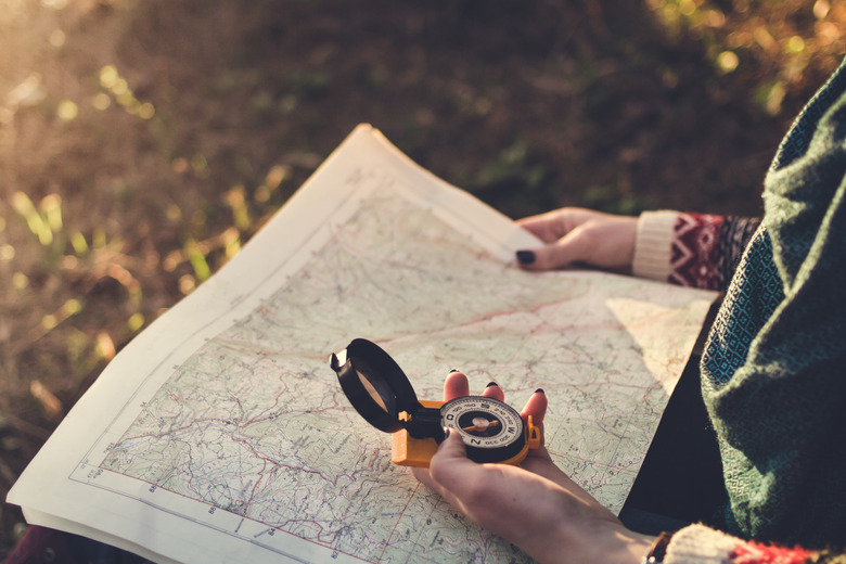 Compass on background of map in the forest