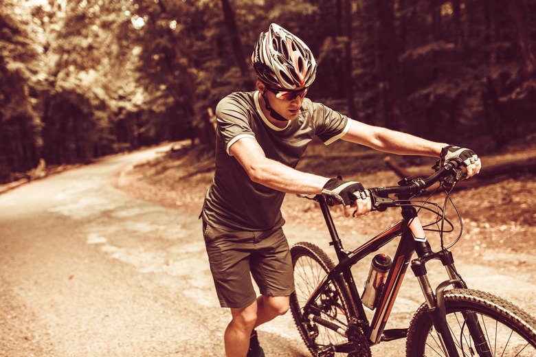 Mountain biker pushing his bike uphill.