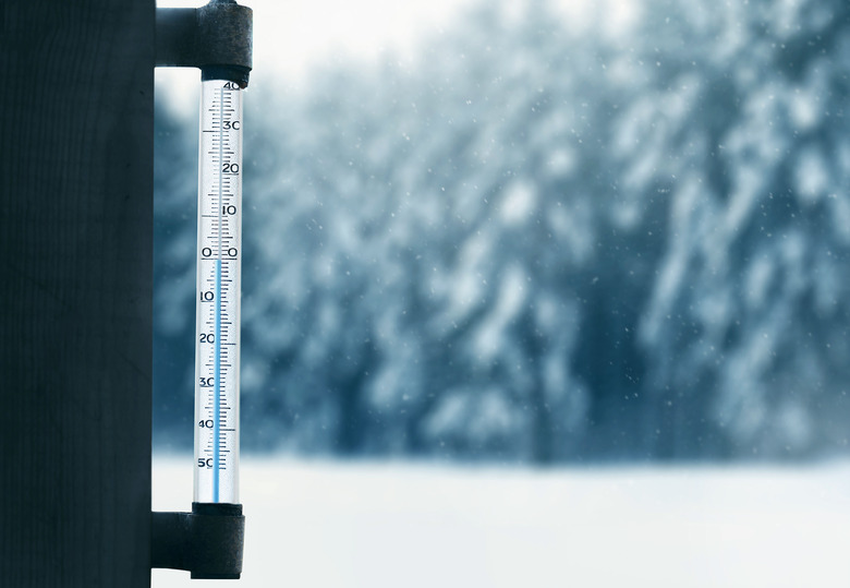 forecasting winter weather thermometer on glass window with forest background