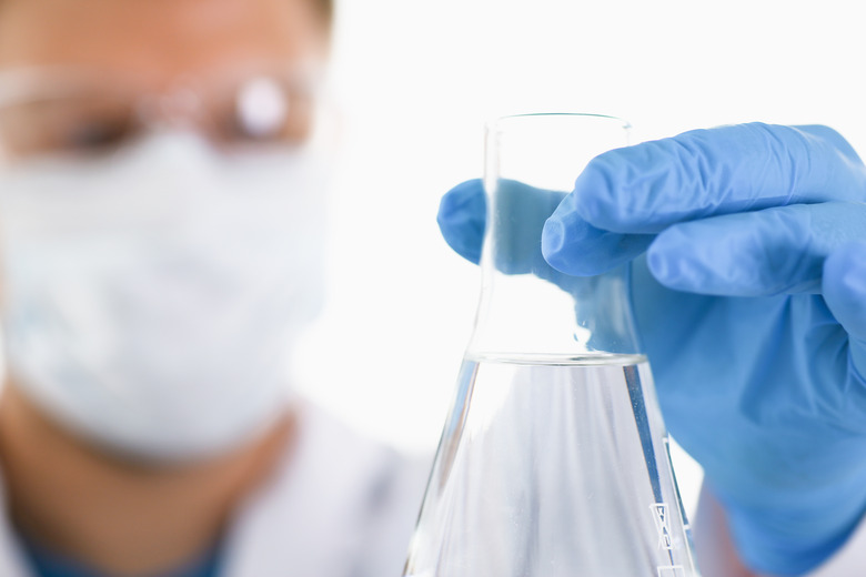 A male chemist holds test tube of glass