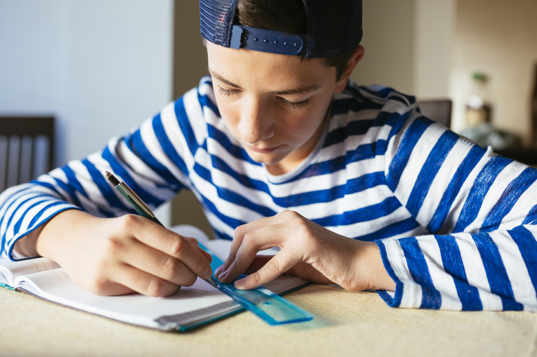 Teenage boy doing homework at living room