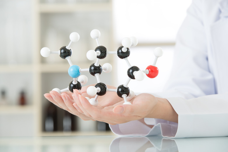 Female scientist teacher holding molecular model