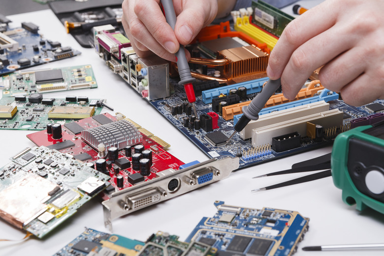 Engineer checking motherboard with multimeter