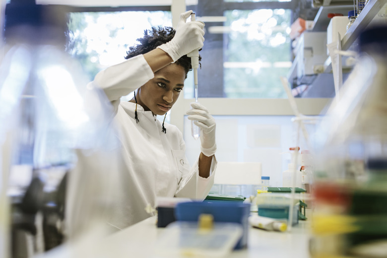 Black female scientist pipetting in a laboratory