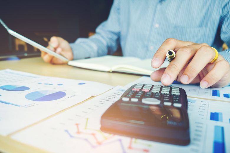 Businessman's hands with calculator at the office and financial data analyzing counting