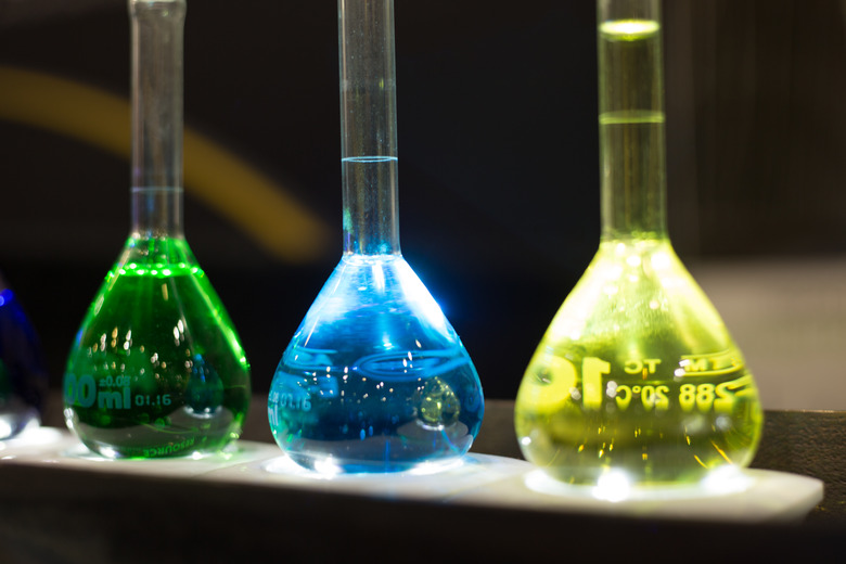 chemistry flasks with yellow, blue and green liquids