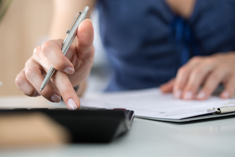 Close up of female accountant or banker making calculations