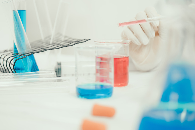 Young Asian scientist working in the lavatory with test tubes and other equipment