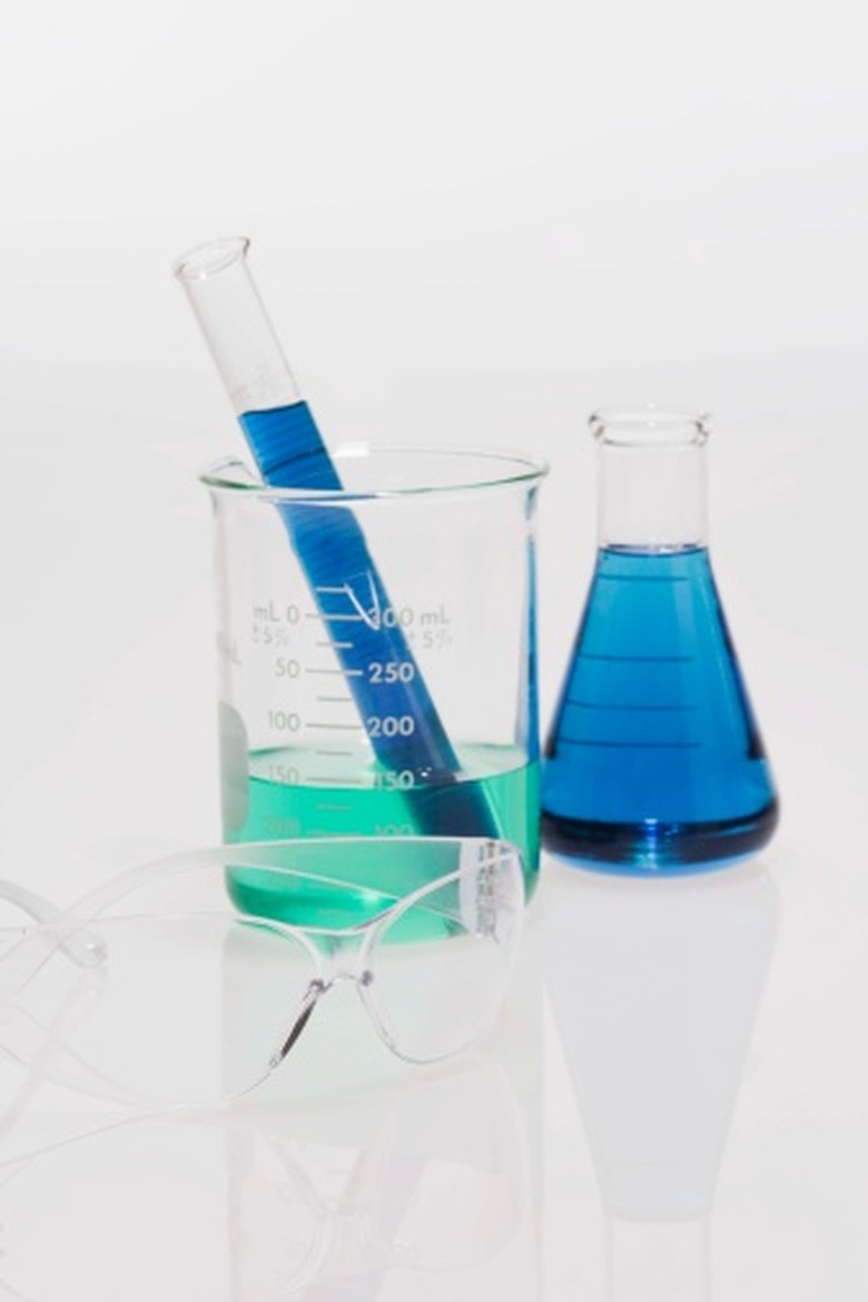 Beakers and flasks filled with blue liquid and safety goggles