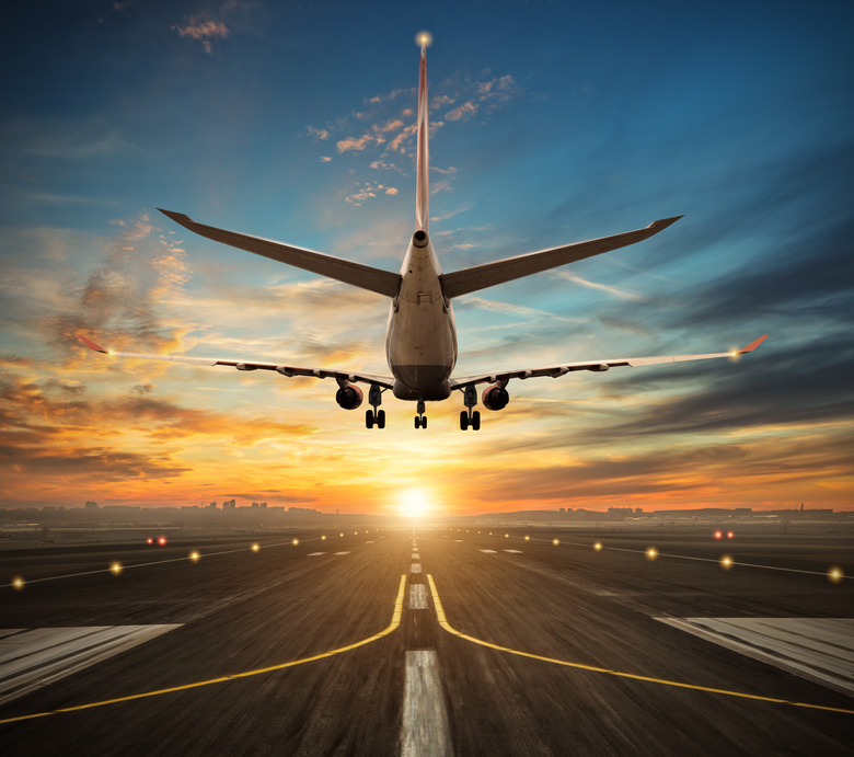 Airplane landing to airport runway in sunset light