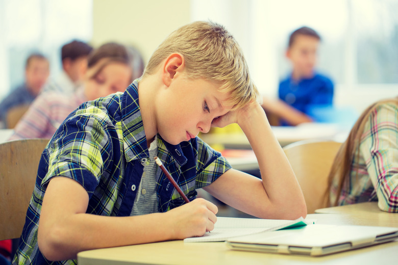 group of school kids writing test in classroom