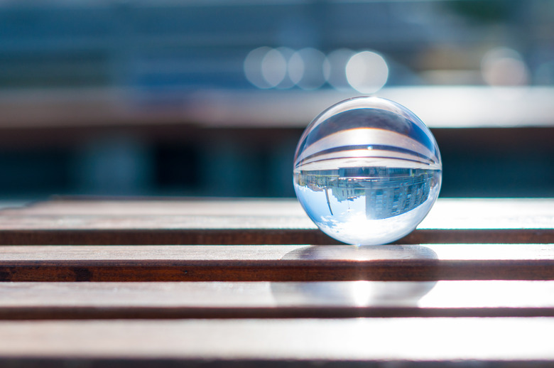 Glass transparent ball on wooden slats background. With empty space