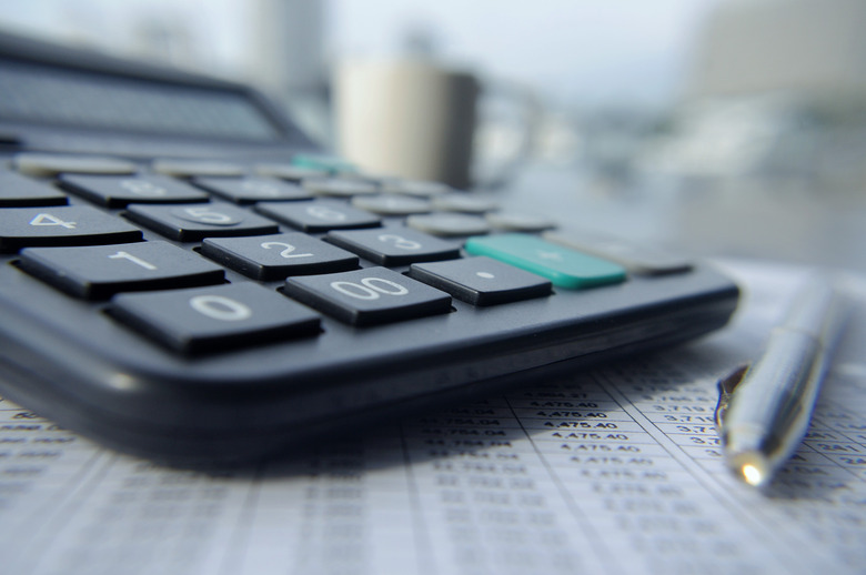 A calculator and a pen on a table