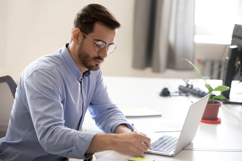 Man sitting at a desk working on a laptop