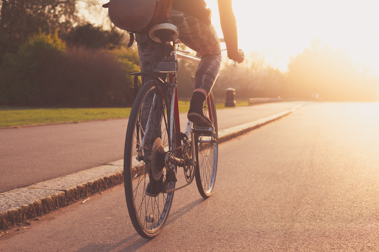 Young woman cycling in the park at sunset