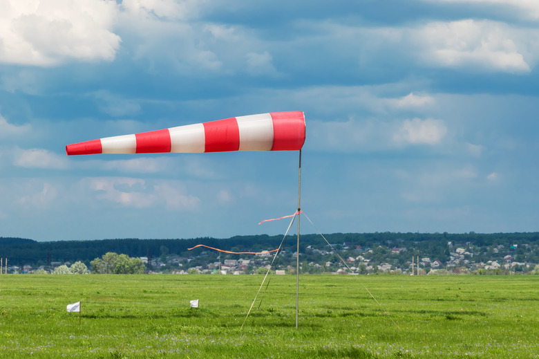 A red and white striped weathervane inflated by the wind