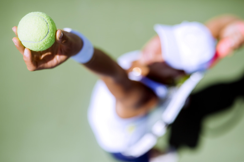 Beautiful female tennis player serving