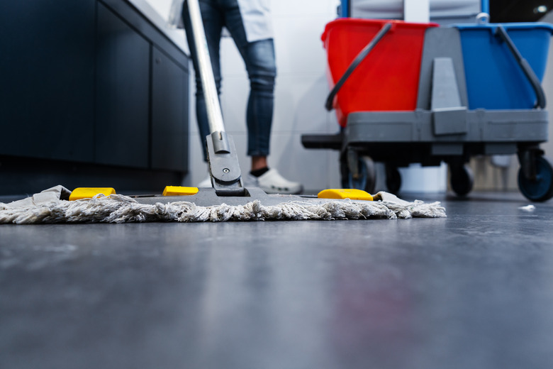 Low shot of cleaning lady mopping the floor in restroom