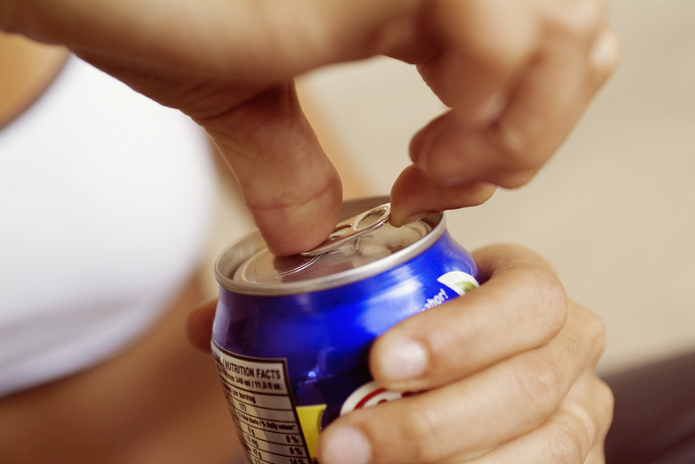 Extreme close-up of woman opening canned drink, focus on foreground