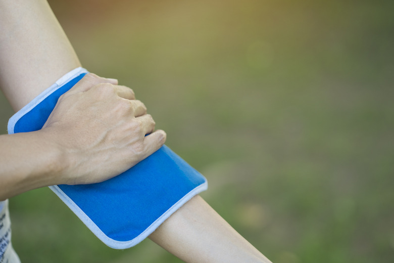 woman putting an ice pack on her arm pain