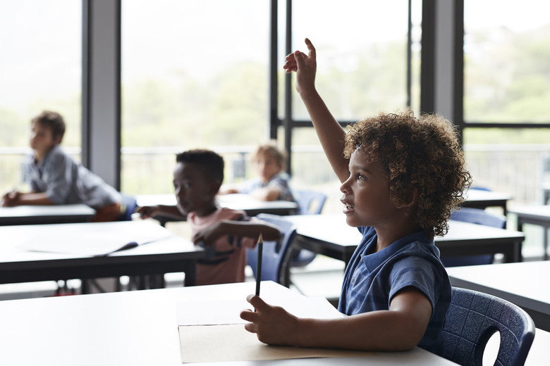 Boy with raised hand in classroom