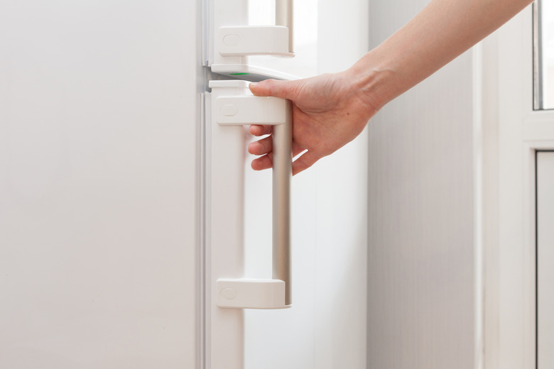 Hand of a young woman is opening a freezer door