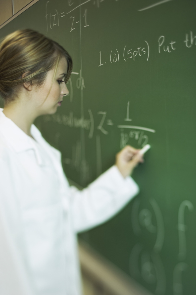 Teenage girl writing on chalkboard