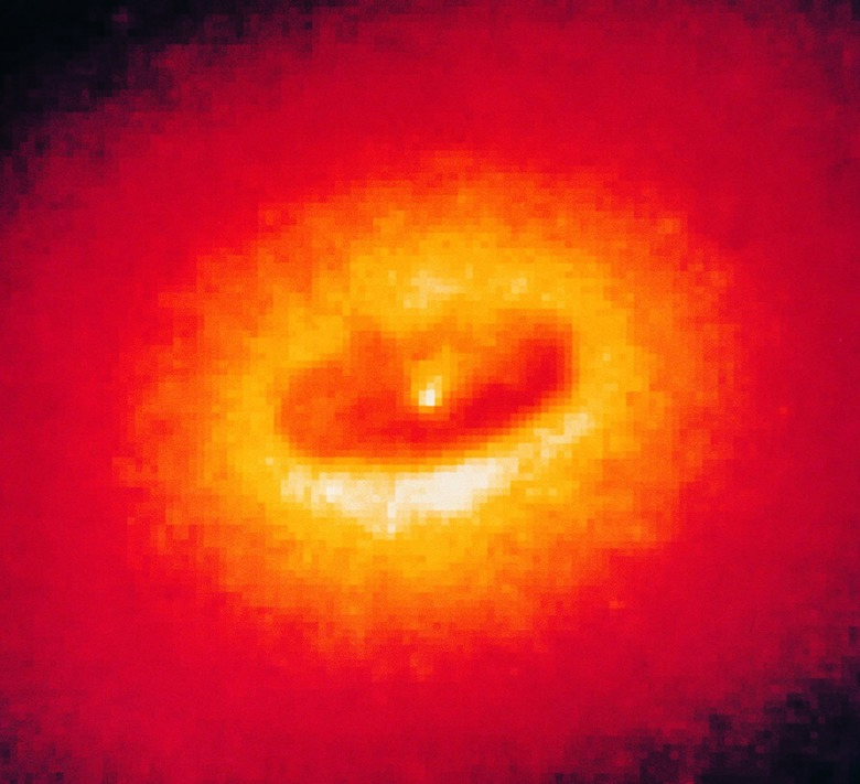 A giant disk of cold gas and dust fuelling a suspected Black Hole