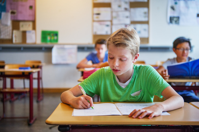 3 male students, writing in exercise book