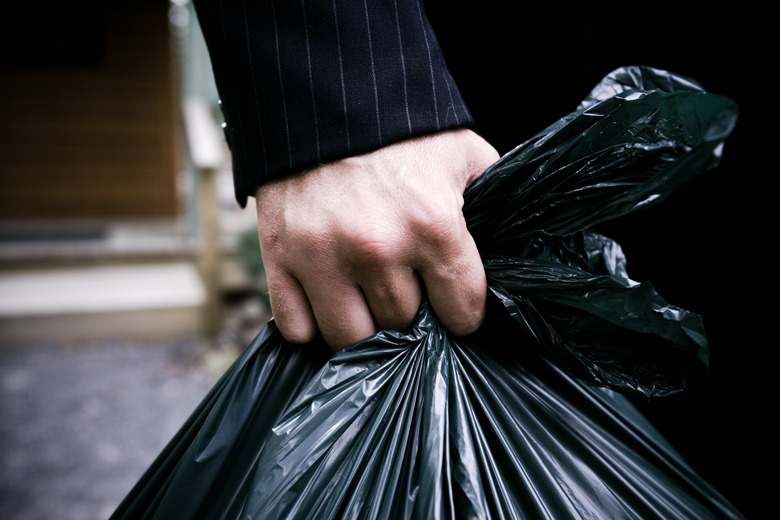 Arm of man carrying trashbag