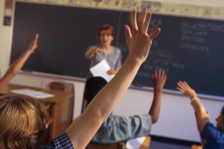 Students raising their hands in classroom