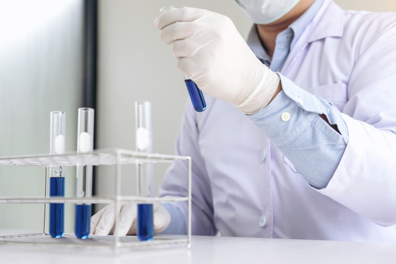 Scientist or medical in lab coat holding test tube with reagent, Laboratory glassware containing chemical liquid, Biochemistry laboratory research