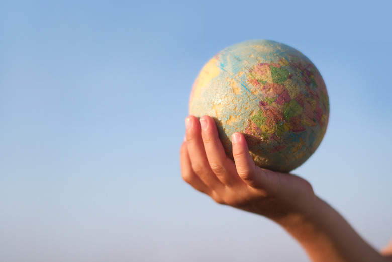 Child hand holding an earth toy globe