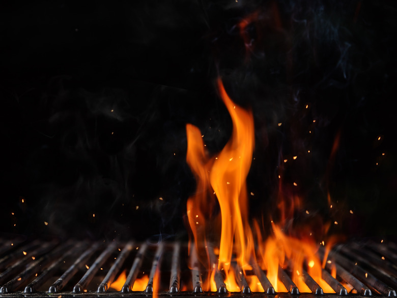 Empty flaming charcoal grill with open fire