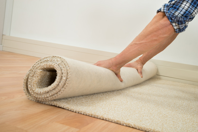 Worker Folding Carpet On Floor