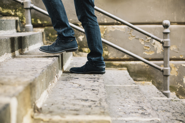 Close-up of man's shoes walking upstairs