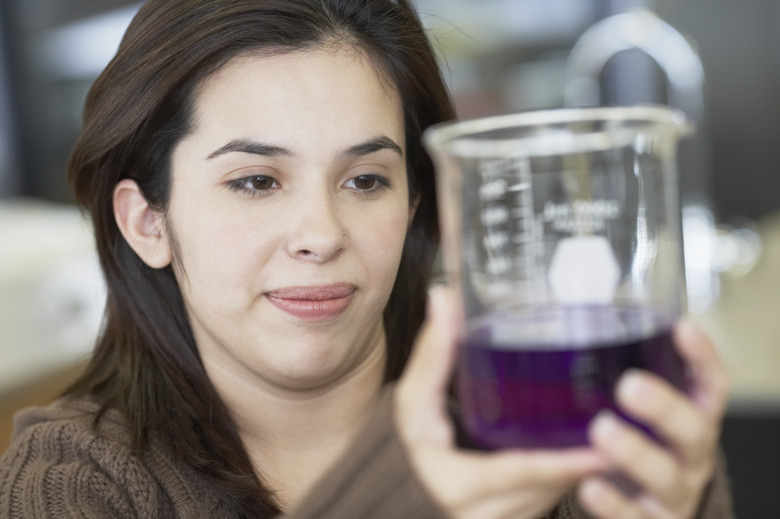 Teenage girl holding a beaker in a laboratory