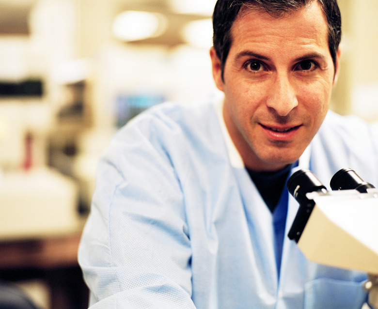 Doctor posing by microscope